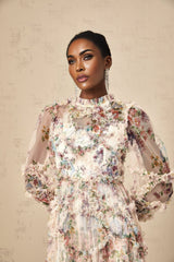 A woman wearing a floral patterned midi dress with ruffled details and a tulle skirt