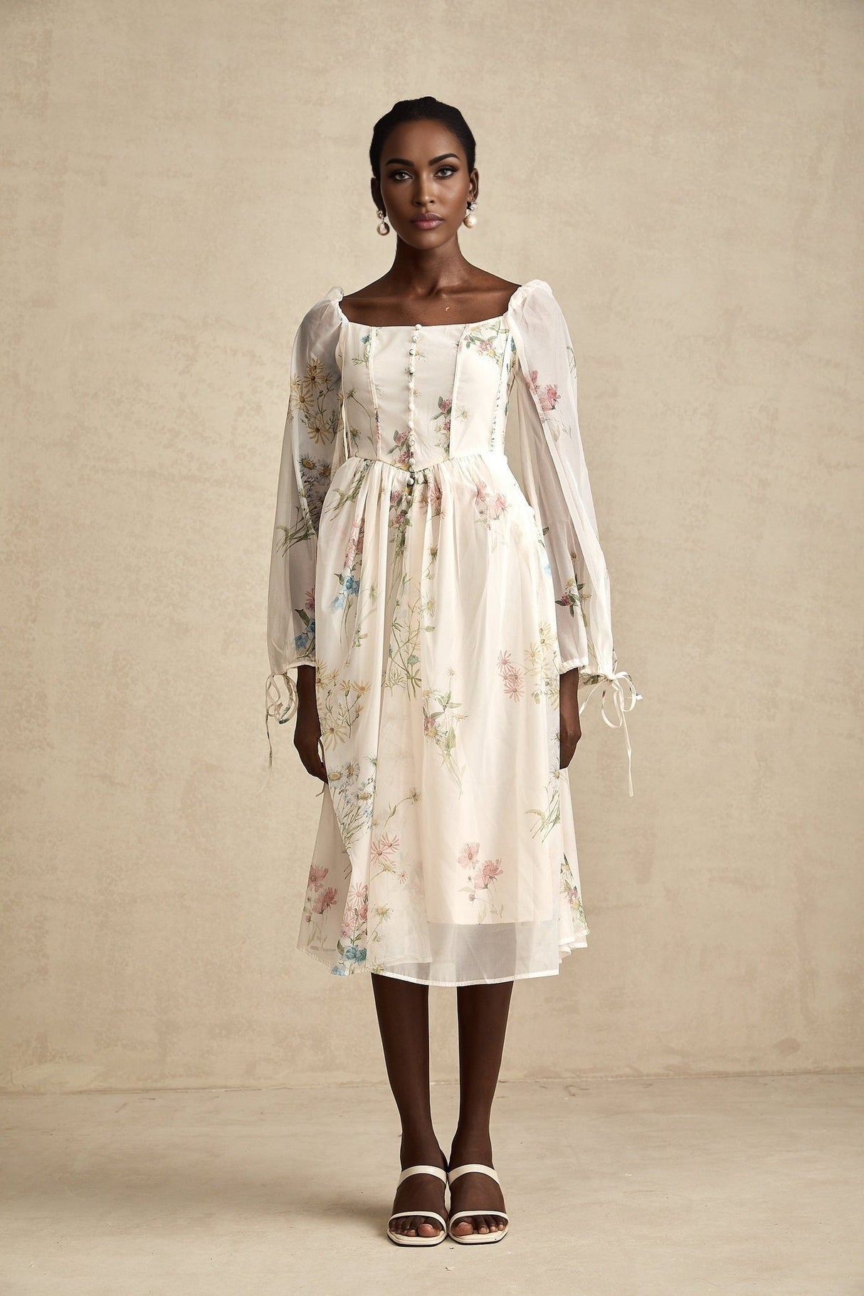A woman wearing a floral print midi dress with a square neckline named Anne