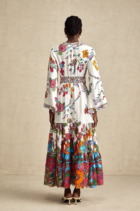 A woman wearing a floral print midi dress with a V neckline and a flowing silhouette in soft colors