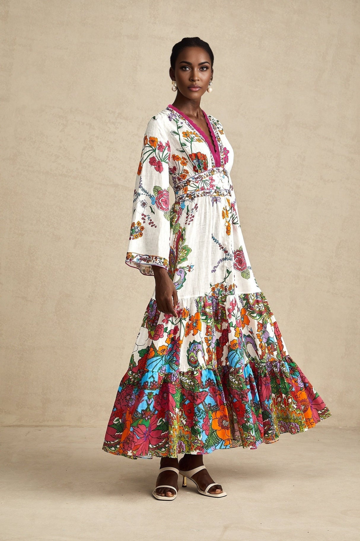 A woman wearing a floral print midi dress with a V neckline and long sleeves standing in a relaxed pose