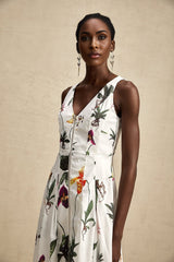 A woman wearing a floral print midi dress with a v neckline and poplin fabric The dress features a colorful floral pattern on a light background and has a flowing skirt that falls to mid calf length