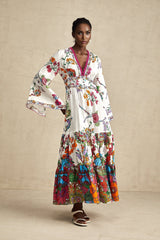 A woman wearing a floral print midi dress with a V neckline featuring a colorful pattern on a light background