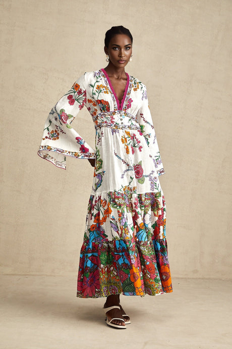 A woman wearing a floral print midi dress with a V neckline featuring a colorful pattern on a light background