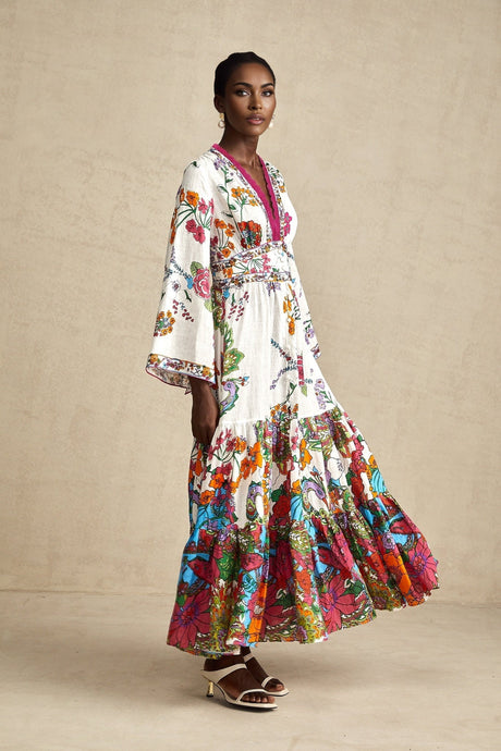 A woman wearing a floral print midi dress with a V neckline standing in a relaxed pose against a plain background