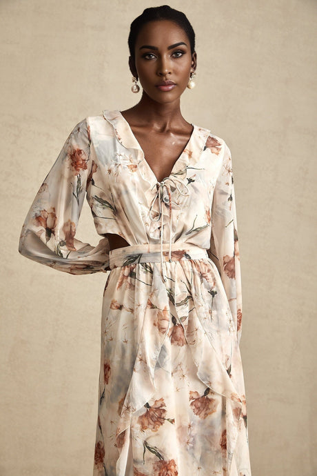 A woman wearing a floral print midi dress with an open waist design The dress features a colorful pattern and falls to mid calf length