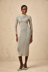 A woman wearing a gold ribbed knit midi dress with delicate pointelle details standing in a relaxed pose