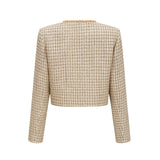 A woman wearing a gold tweed jacket and matching skirt set with sequin embellishments The outfit has a luxurious and sparkly appearance suitable for formal occasions