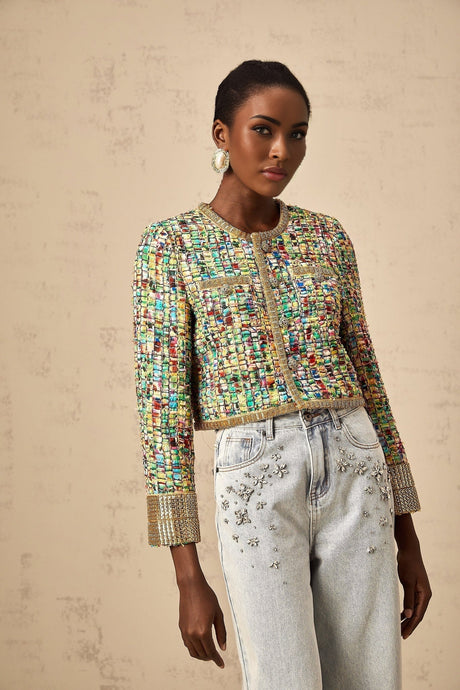 A woman wearing a gold tweed jacket with a checked pattern and sequin embellishments