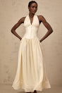 A woman wearing a halterneck tulle midi dress in a soft shade standing against a plain background The dress features a fitted bodice and flowy skirt with delicate tulle layers
