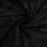 A woman wearing a long black maxi dress with a single shoulder strap and a cutout detail on one side