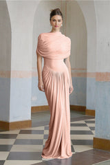 A woman wearing a long pink asymmetric maxi dress with pleated details and a flowing skirt