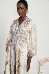A woman wearing a long sleeve floral print bohemian style dress with a flowing silhouette and vibrant colors