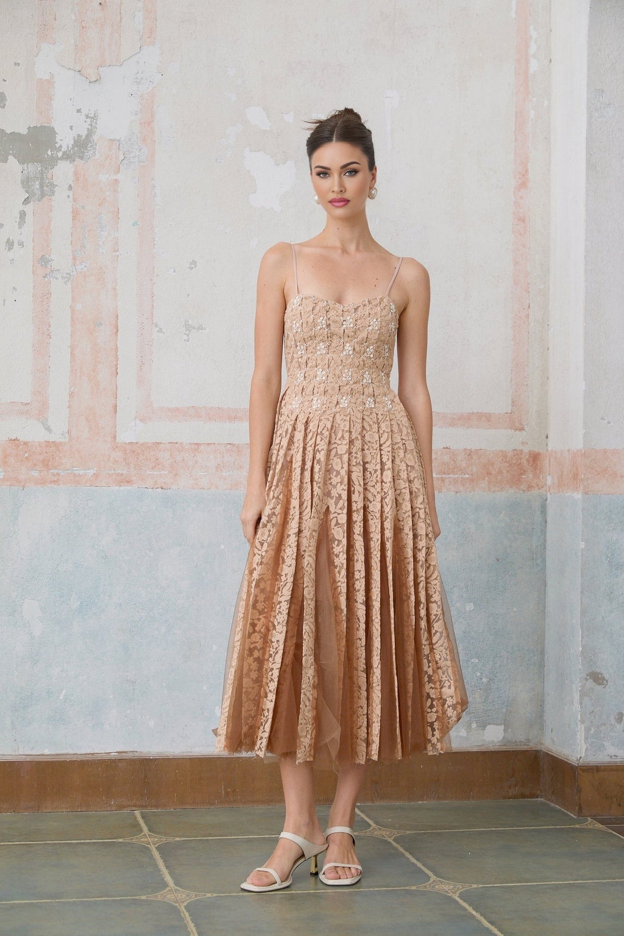 A woman wearing a matching cream colored crochet lace cardigan and dress set The dress is sleeveless and knee length while the cardigan has long sleeves Both pieces feature intricate lace patterns