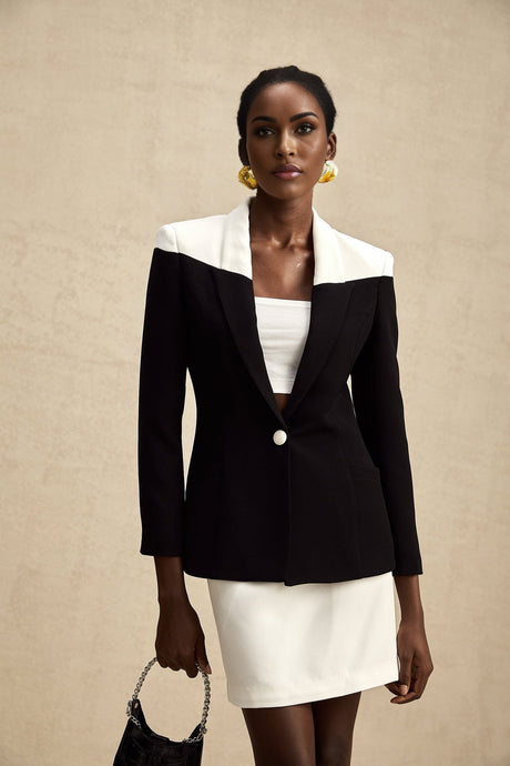 A woman wearing a matching jacket and skirt set in contrasting colors from the Honorine collection