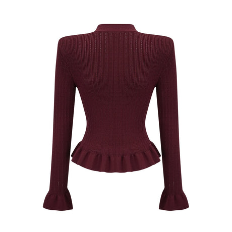 A woman wearing a matching red knit set consisting of a ruffled top and skirt The top features short sleeves and ruffled details while the skirt has a fitted silhouette Both pieces are in a vibrant red color