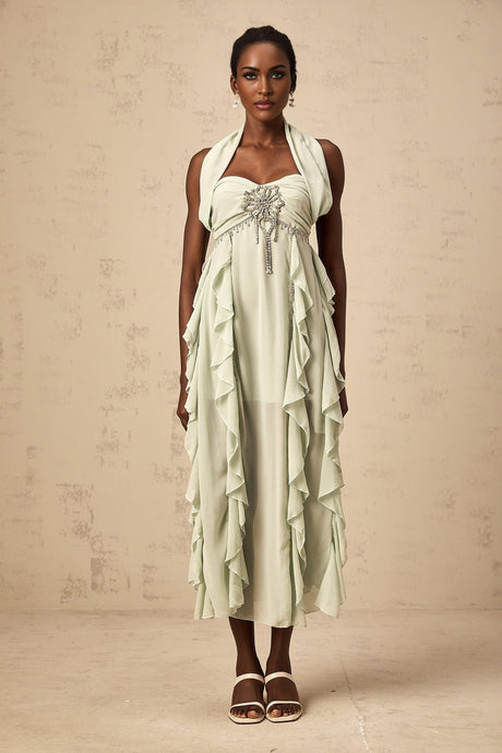 A woman wearing a midilength dress with ruffled details and embellishments named Salilah