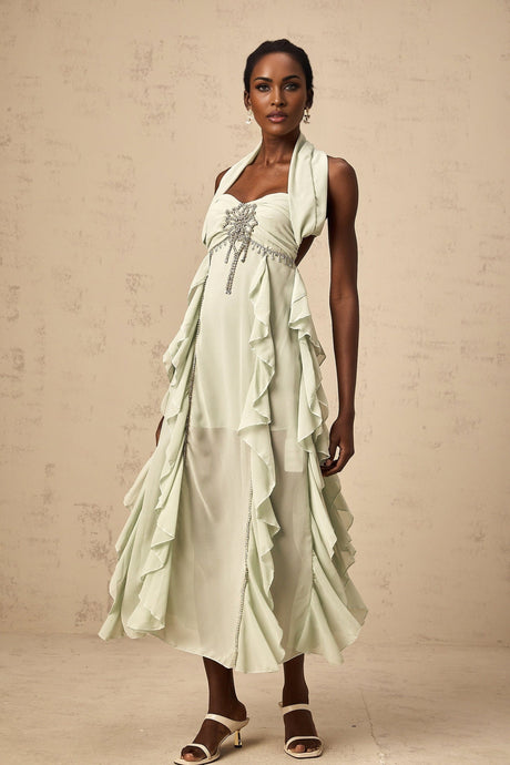 A woman wearing a midilength dress with ruffled details and embellishments named Salilah