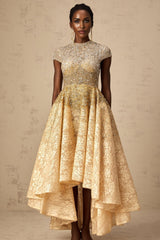A woman wearing a neutral colored sequined dress with a high low hemline