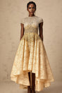 A woman wearing a neutral colored sequined dress with a high low hemline