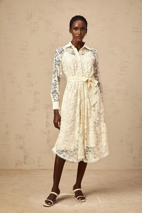 A woman wearing a neutralcolored midi shirt dress with guipure lace detailing standing in a casual pose