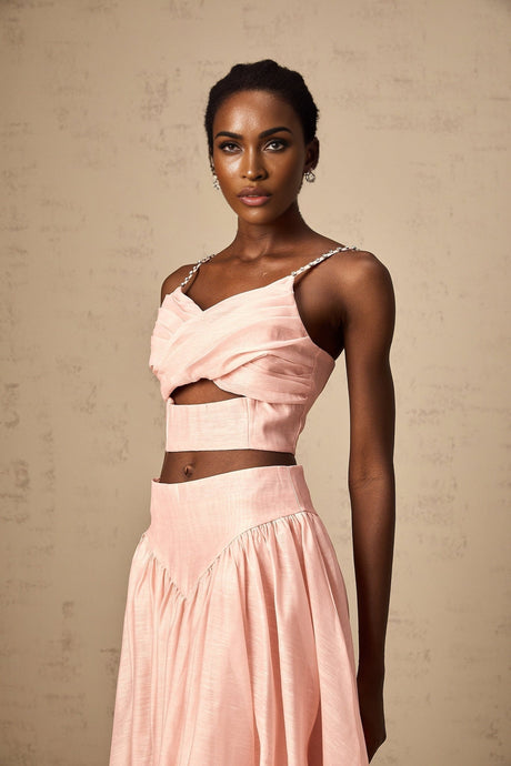 A woman wearing a pink matching set consisting of an asymmetric ruffled top and skirt The top features a oneshoulder design with ruffles while the skirt has a fitted silhouette Both pieces are in a vibrant pink color