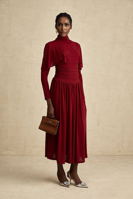 A woman wearing a red midi dress with ruched details and a flap design on the front