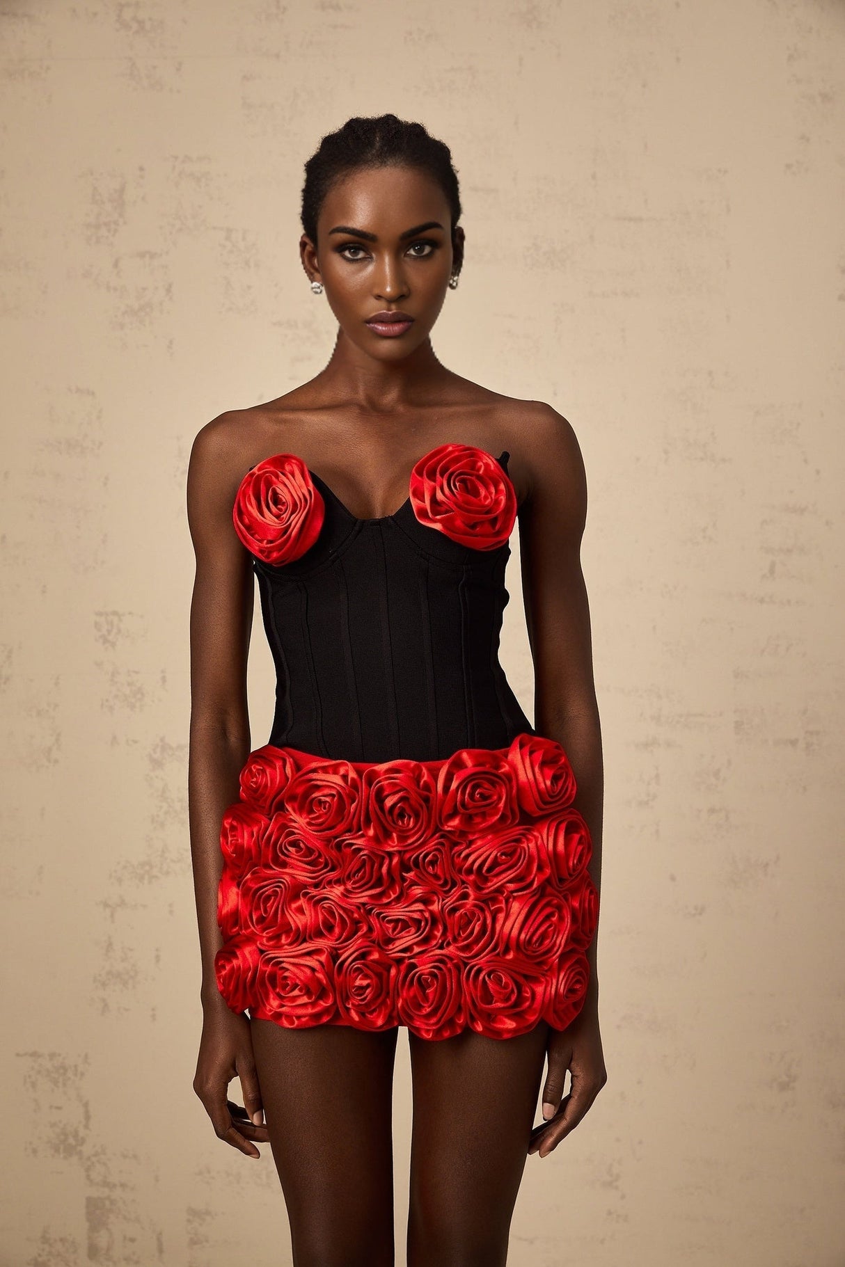 A woman wearing a red twopiece outfit consisting of a top and skirt with rose applique designs matching set