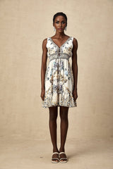 A woman wearing a short floral print dress with a vneck neckline The dress features a vibrant pattern and falls above the knee