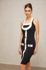 A woman wearing a short halterneck knit dress with color blocks featuring contrasting colors The dress has a fitted silhouette and ends above the knee