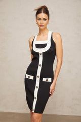 A woman wearing a short halterneck knit dress with contrasting color blocks styled in a modern design