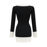 A woman wearing a short wool dress with color blocks and ribbed texture featuring long sleeves and a high neckline