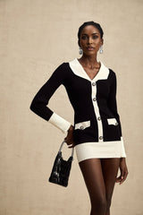 A woman wearing a short wool dress with colorblocked sections and ribbed texture The dress features different colored panels in a stylish mini length design