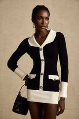 A woman wearing a short wool dress with ribbed knit texture featuring color block design in different shades standing against a plain background