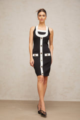 A woman wearing a sleeveless knit mini dress with a halter neckline The dress features color blocking with contrasting sections The model stands in a relaxed pose showing the fitted silhouette of the dress