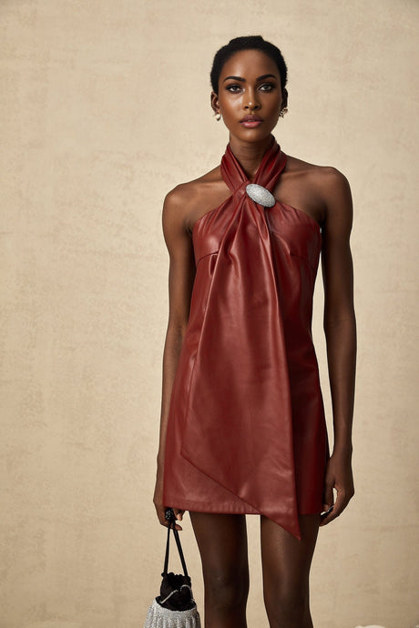 A woman wearing a vibrant red halterneck mini dress made of sheepskin with a fitted silhouette and bare shoulders