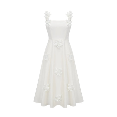 A woman wearing a white midi dress with a square neckline and faux flower embellishments standing in a neutral background
