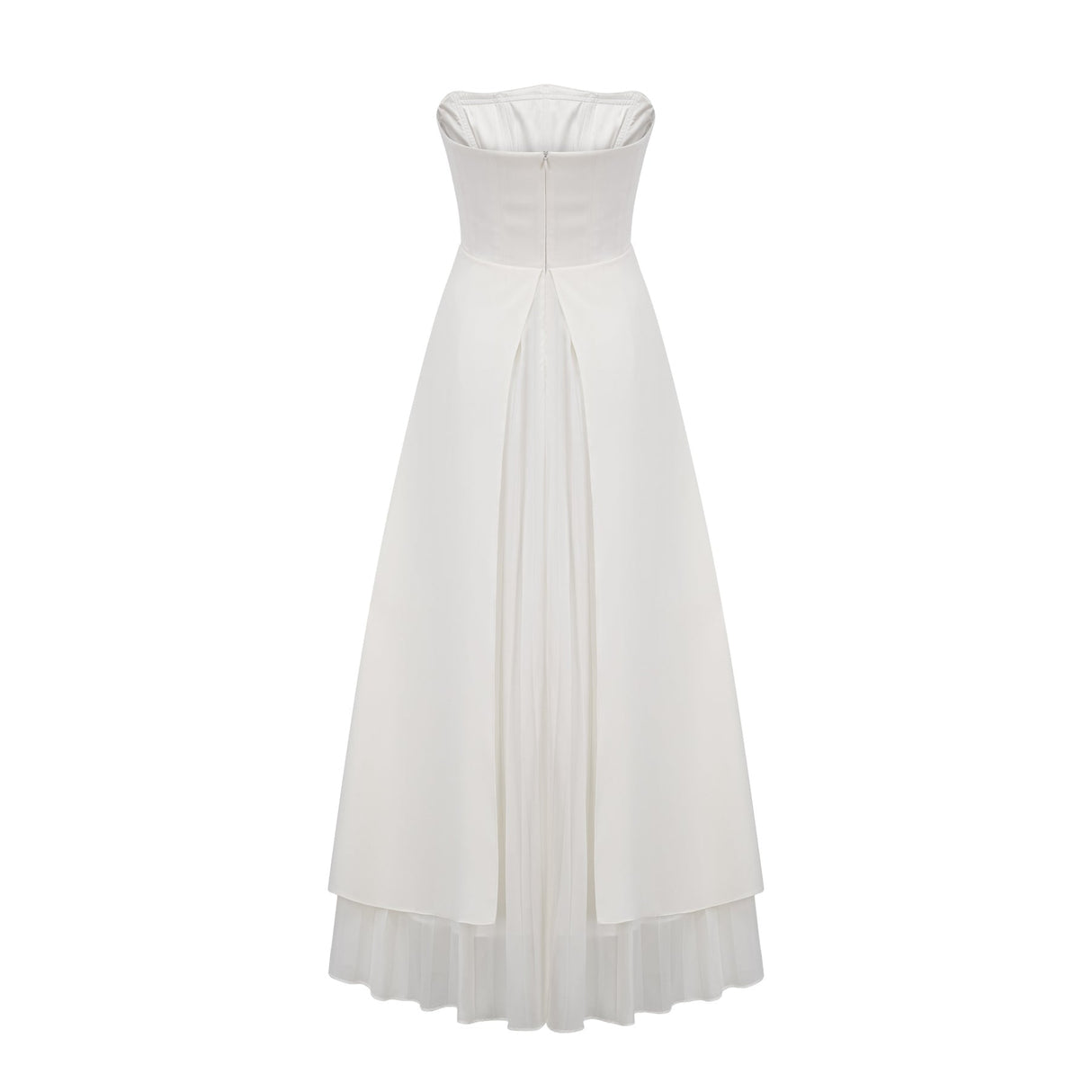 A woman wearing a white pleated offshoulder maxi dress with a flowing skirt standing against a plain background