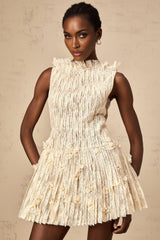 A woman wearing a white semisheer mini dress with lace details and a crinkled texture standing in a casual pose