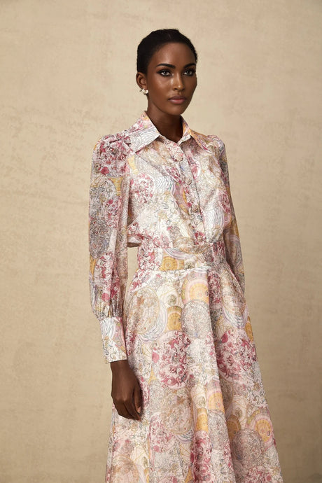 A young girl wearing a cherry pink shirt and matching skirt both featuring a repeating pattern print The set includes a top with short sleeves and a flared skirt creating a coordinated outfit