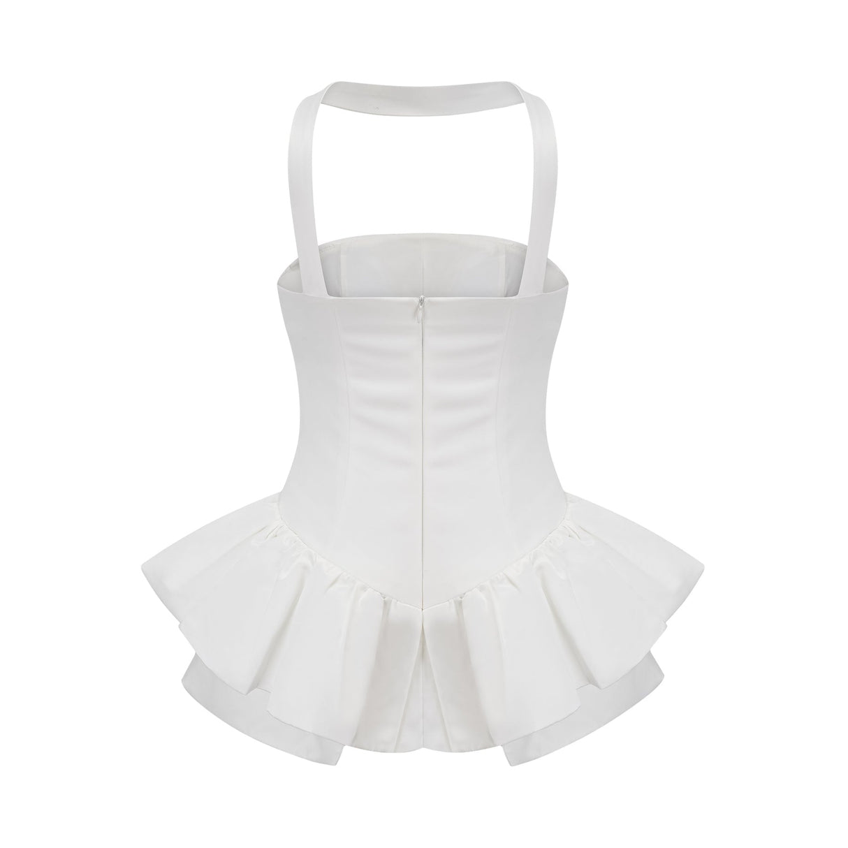 A young woman wearing a white halterneck mini dress with ruffled details standing against a plain background