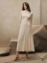 This elegant cream lace dress features a sophisticated high neckline and long sleeves, creating a timeless silhouette that's.
