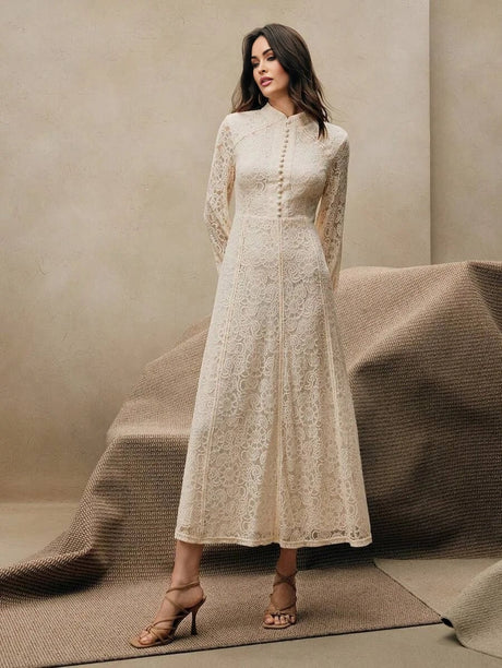 This elegant cream lace dress features a sophisticated high neckline and long sleeves, creating a timeless silhouette that's.