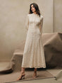 This elegant cream lace dress features a sophisticated high neckline and long sleeves, creating a timeless silhouette that's.