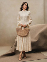 A delicate cream-colored lace dress features a high neckline and elegant, flowing sleeves, offering a flattering A-line.