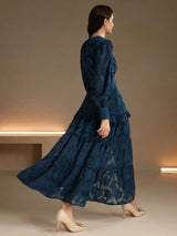 This elegant navy blue dress features intricate floral patterns and a flowing tiered design that gracefully sways with.