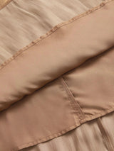 This elegant dress features a soft, shimmering beige fabric that gracefully drapes over the body, highlighting its.