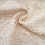 An offwhite blouse with floral lace detailing and a bow accent named Anaelle