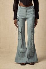 Beige flared cargo trousers with belt loops and multiple pockets worn by a model standing against a plain background