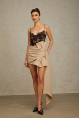 Beige mini skirt with ruched fabric and decorative bow detail at waist