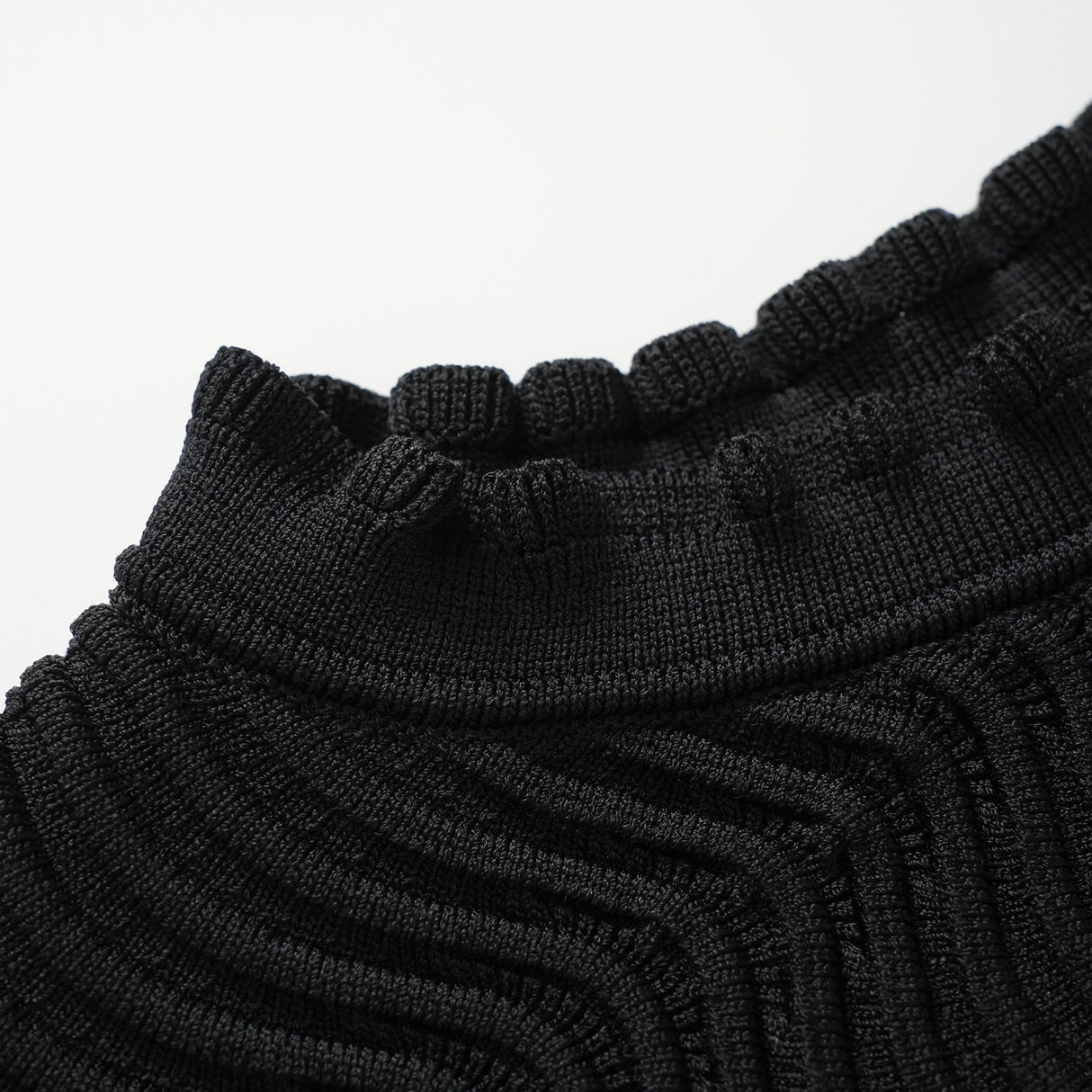 Black bodycon dress with textured wave pattern and ruffled collar and sleeves